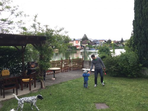 Grillen und Ball spielen im Garten am See